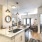 Spacious and well lit kitchen with wood floors and stainless steel appliances. 
